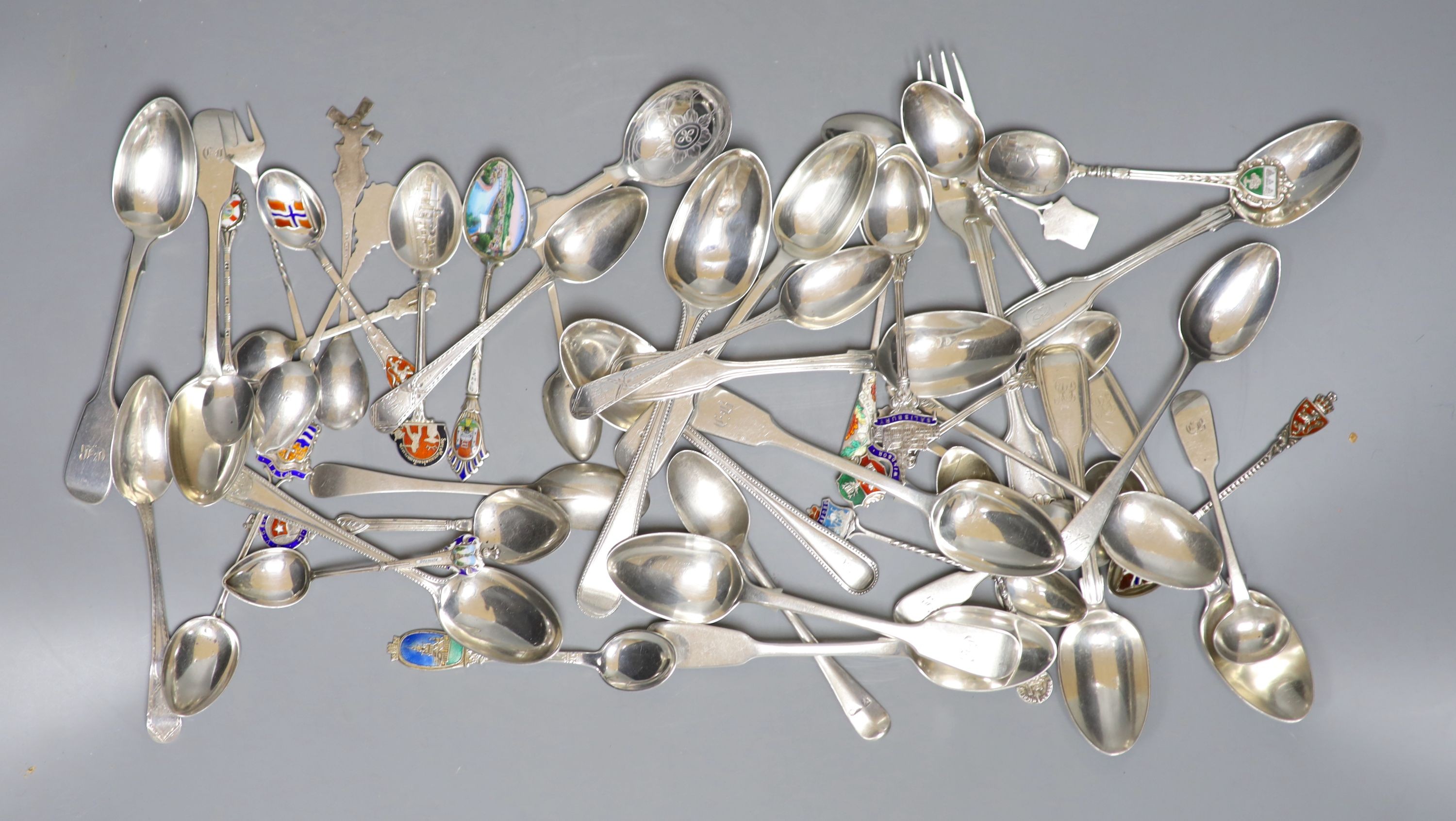 A mixed collection of assorted mainly silver and white metal tea and souvenir spoons, a Georgian silver caddy spoons and two forks, gross 27.5oz.